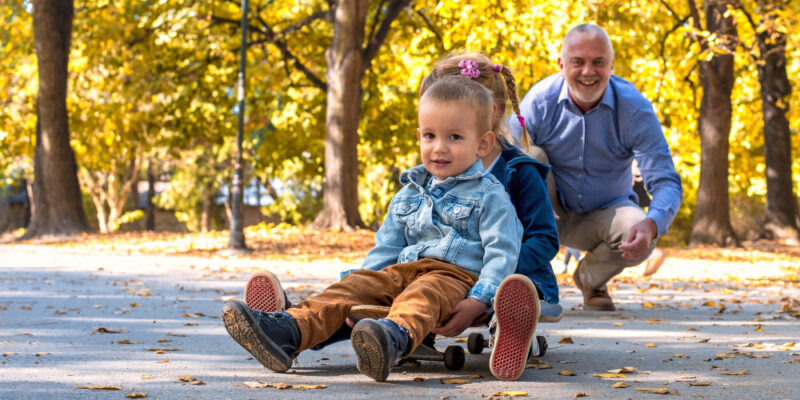 Bunic cu nepoti jucandu-se in parc